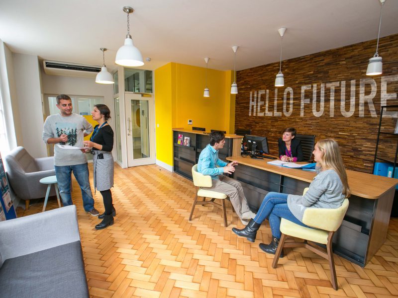 Stafford House reception with a yellow wall and Hello Future timber feature